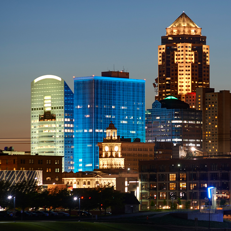 MezzoOnWalnut_Skyline_Square-Web Downtown Des Moines skyline with Financial Center and Mezzo lit up in blue lights at dusk