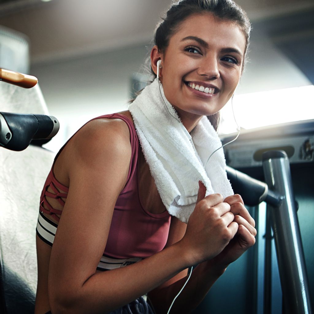 Woman working out with towel and airpods