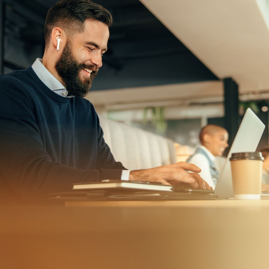 Person working on laptop with airpods